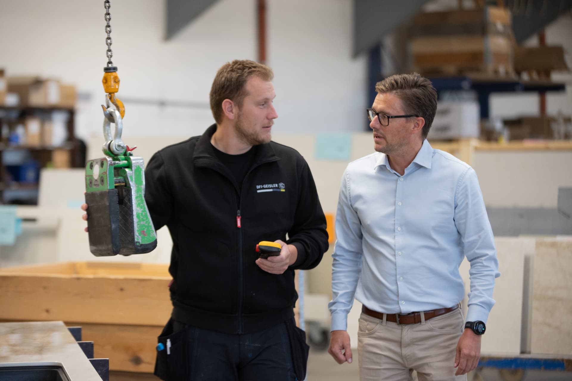 To kolleger i produktionen hos DFI-GEISLER med vakuumløfter