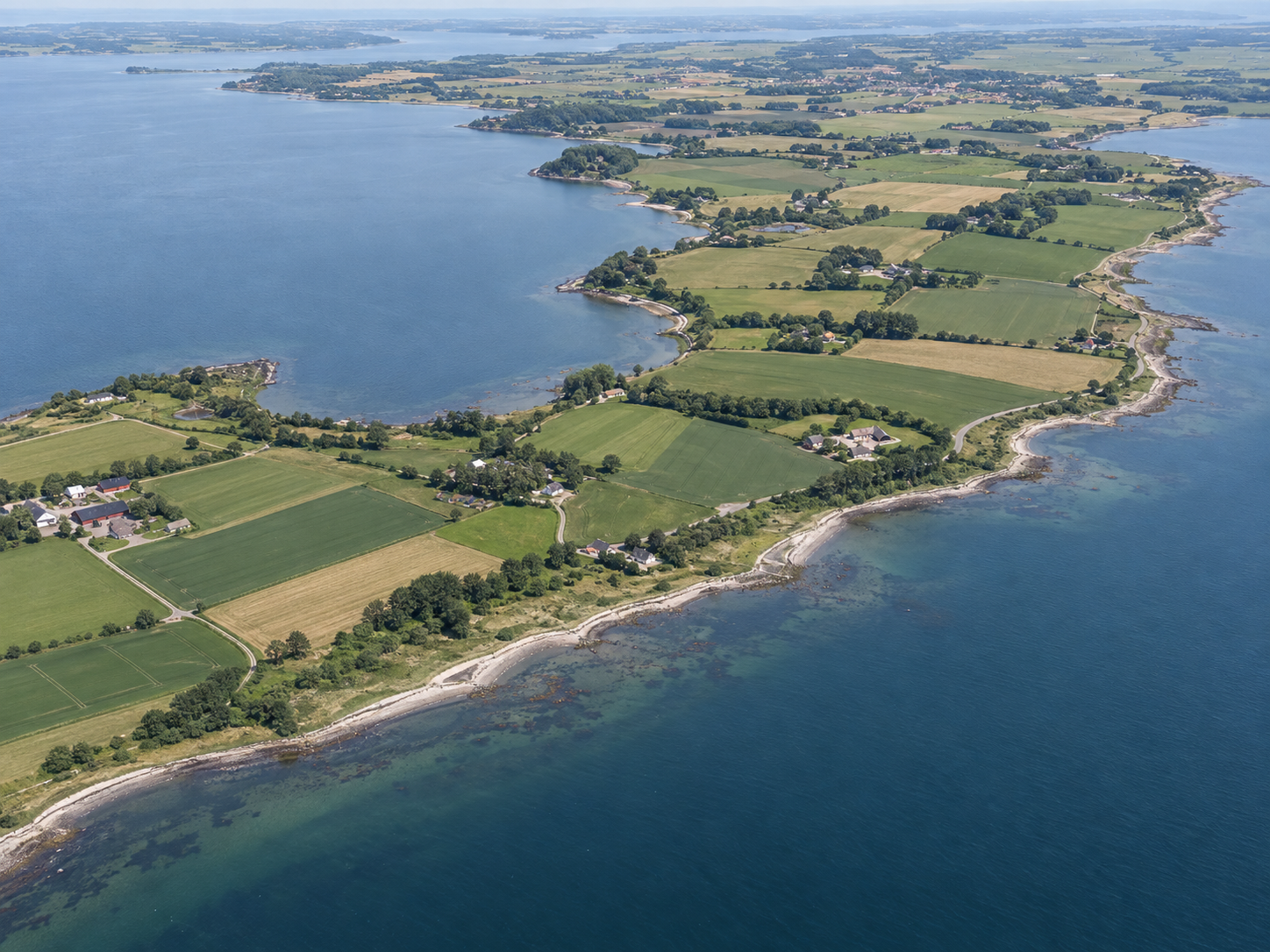 Luftfoto af kystlinje og marker ved Limfjorden